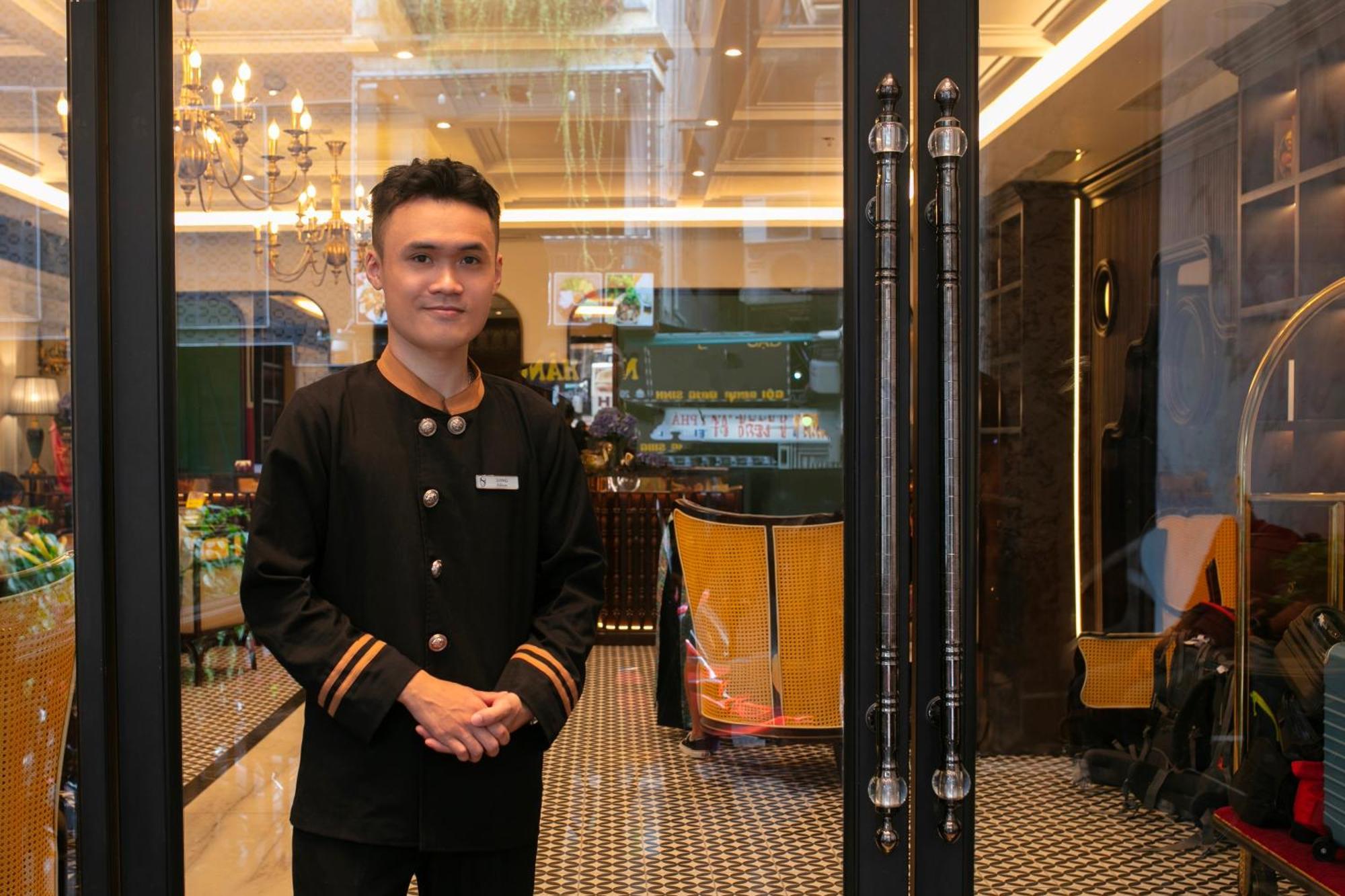 May De Ville Crown Hotel ハノイ市 エクステリア 写真 A doorman at the entrance of a hotel in Kuala Lumpur, Malaysia